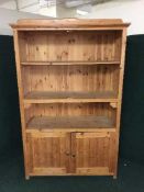 A large set of stripped pine shelves fitted cupboard below