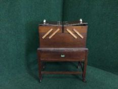 A mahogany concertina sewing trolley