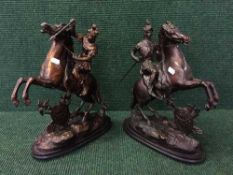 A pair of cast metal figures depicting warriors on horseback