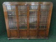 An early twentieth century carved oak four door display cabinet,