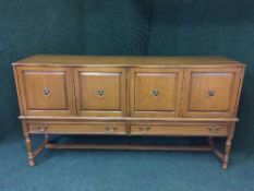A continental oak four door sideboard with lion mask handles