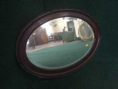 An early 20th century oval mahogany framed mirror
