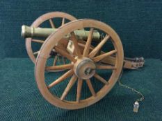 A miniature brass cannon on wooden carriage