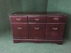 A contemporary mahogany sideboard with brass drop handles