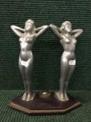A cast metal Art Deco style ornament depicting pair of nude females on plinth