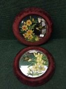 A pair of early 20th century hand painted circular mirrors in velvet frames