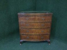 A walnut five drawer bow-fronted chest with brushing slide