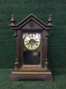 An early 20th century oak cased mantel clock in architectural case