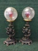 A pair of early 20th century cast metal lamps with glass shades,