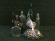 A box of collection of antique glass bottles and a bag of marbles