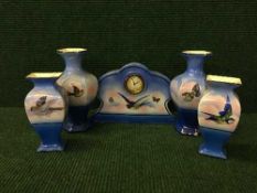 An early 20th century china five piece mantel clock garniture