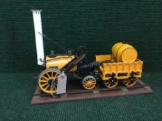 A live steam 'Rocket' engine with coal carriage on stand