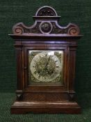 A Victorian carved oak eight day bracket clock with brass dial