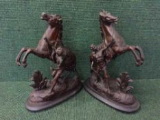 A pair of cast metal figures depicting horses