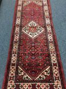 A fringed north west Persian runner on red ground 230 cm x 87 cm