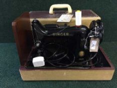 A cases singer electric sewing machine together with a cased manual typewriter