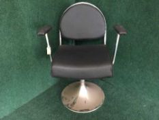 A contemporary chrome and black leather swivel armchair