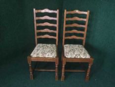 A pair of oak ladder back dining chairs