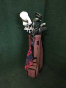 A golf bag containing drivers and Ben Sayers irons
