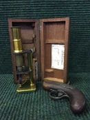 A cased miniature brass microscope and a miniature flintlock pistol