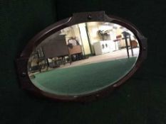 An oak framed Arts and Crafts oval mirror