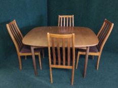 A mid 20th century teak extending dining table and four chairs