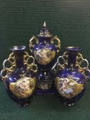 A late 19th century three piece decorative blue and gilt vase set with classical decoration