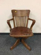 An Edwardian oak revolving desk chair