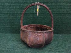 An early 20th century stitched and embossed leather basket