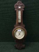 An Edwardian carved mahogany cased barometer