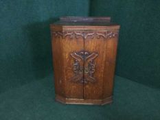 An early 20th century carved oak cabinet fitted three drawers