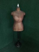 A dress maker's dummy on stand bearing the name 