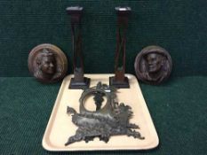 A pair of Art and Crafts candlesticks, carved wooden wall plaques,