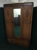 An Edwardian oak mirror door wardrobe and dressing chest