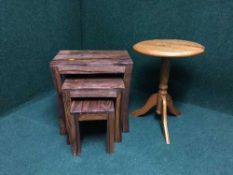 A nest of three hardwood tables together with a pine pedestal table