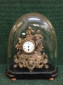 A late 19th century gilt metal mantel clock with pendulum under glass dome