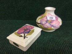 A Moorcroft white magnolia squat vase with pink and purple flowers,