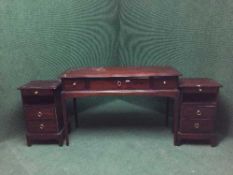 A mahogany stag dressing table fitted with three drawers together with a pair of bedside stands
