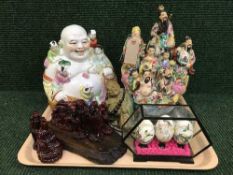 A tray of oriental figures, hand painted eggs in display case,