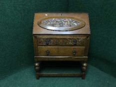 A heavily carved oak bureau