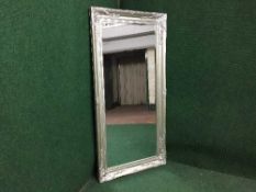 A contemporary silvered framed bevelled mirror
