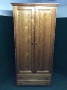 A pine double door wardrobe fitted with two drawers