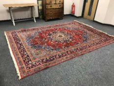 A fringed Persian carpet on red ground
