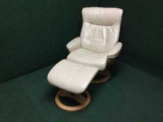 A contemporary cream leather relaxer chair with stool