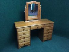 A pine knee hole dressing table fitted with eleven drawers