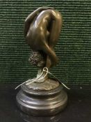 A bronze figure on stone base - Erotic study of standing lady bending down.