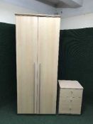 A beech effect double door wardrobe and three drawer chest