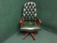 A green buttoned leather swivel desk chair