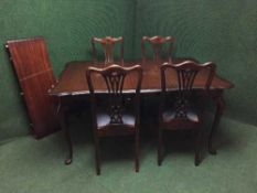 A mahogany extending dining table with leaf together with a set of four chairs