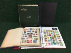 A basket of four stamp albums